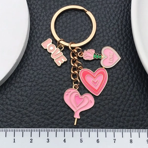 Pink heart and rose enamel keychain with gold metal ring on black leather background