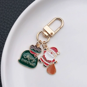 Détail du Père Noël et du sac cadeau vert sur un porte-clés festif doré brillant