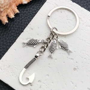 Vintage silver fishing keychain with three textured fish charms and a large hook pendant