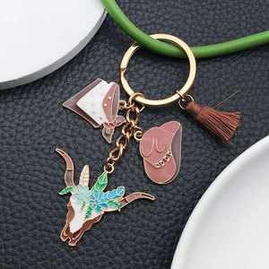 Western keychain with brown cowboy hat, bull skull pendant and tassels on black leather