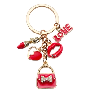 Portachiavi chic con labbra rosse, cuore e borsa in lega dorata su sfondo bianco