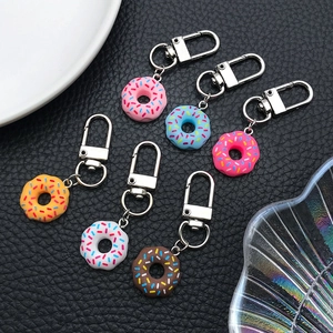 Détail de porte-clés donuts en acrylique coloré en six couleurs sur cuir noir