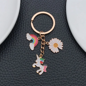 Detail of rose gold keychain with rainbow, daisy and colorful unicorn enamel charms