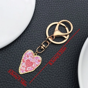 Detail view of heart-shaped keychain with pink patterns and 8.5cm length dimensions