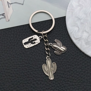 Detailed macro view of antique silver cactus keychain charms with embossed metal textures