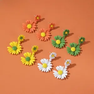 Detailed macro view of daisy earrings in orange, green, yellow, and white colors