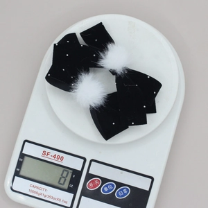 Coppia di fermagli per capelli a fiocco in velluto nero con pompon bianchi e strass
