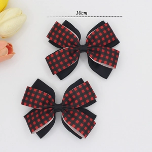 Detail view of 10cm red and black buffalo plaid ribbon bow hair clips on white background