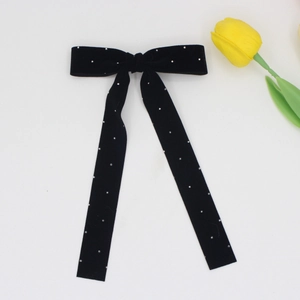 Detail shot of black velvet bow hair clip with sparkling silver rhinestones and long ribbons
