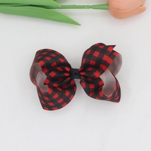 Detail of red and black buffalo plaid ribbon bow hair clip with textured ribbing fabric