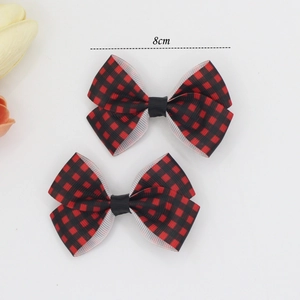 Detail view of two 8cm red and black buffalo plaid ribbon bow hair clips for women
