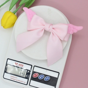 Pince à cheveux nœud avec ailes roses pour filles, pesant environ 10,7g sur balance