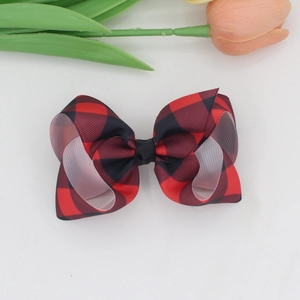 Detailed macro view showing the texture of a classic red and black plaid ribbed bow hair clip