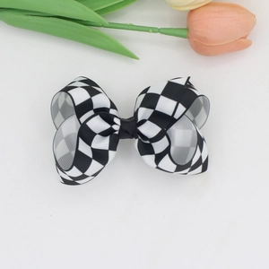 Detail of checkered ribbed ribbon bow hair clip on white background with tulip