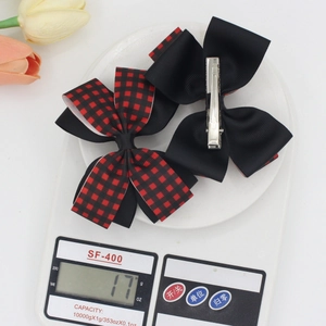 Pair of black and red plaid grosgrain ribbon bow hair clips weighing 17g on a scale