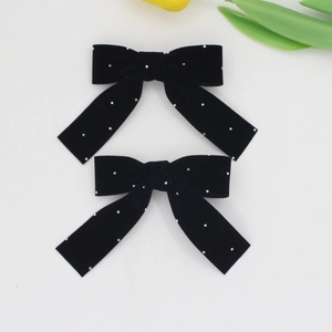 Close-up of elegant black velvet bow hair clips with sparkling rhinestone detailing