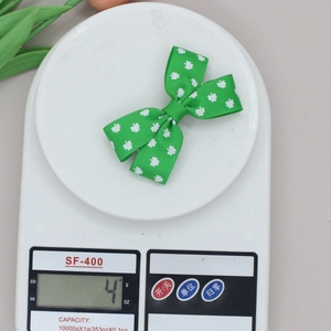 Green St. Patrick's Day clover bow hair clip shown on a scale weighing exactly 4g