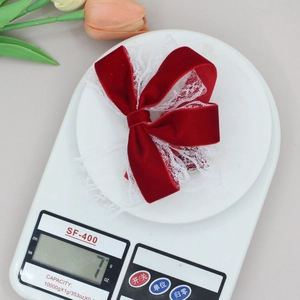 Elegant red velvet bow hair clip with white lace trim weighing exactly 7g on a scale