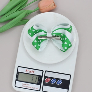 Close-up of Saint Patrick's Day clover bow hair clip on a scale weighing 11g