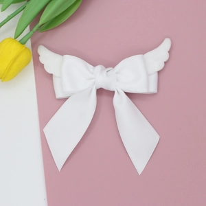 Barrette à cheveux avec ailes d'ange en peluche et nœud blanc sur fond rose doux