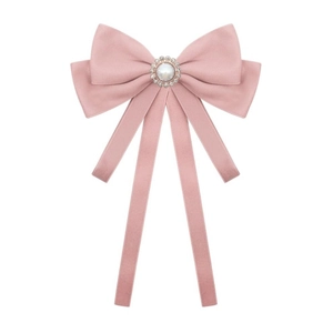 Detailed macro view of pink velvet bow brooch with center pearl and sparkling rhinestones