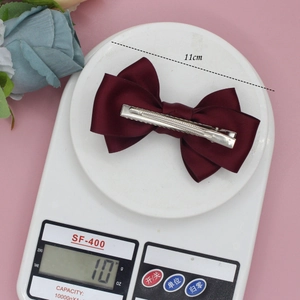 Eleganter weinroter Satin-Schleife Haarclip mit silberner Metallspange auf Pink