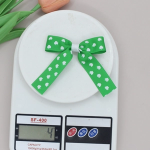 Detail showing a lightweight St. Patrick's Day green clover bow hair clip weighing only 4 grams
