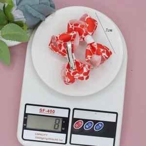 Three Valentine heart print ribbon hair clips with LOVE text and silver alligator clips