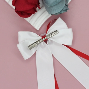 Barrette à cheveux avec nœud en soie rouge et blanc et longs rubans sur rose