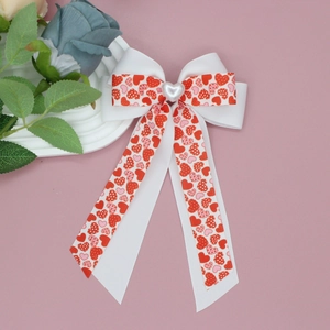 Detail of sweet bow hair clip with heart print ribbon and heart pearl center