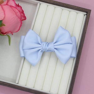 Eleganter hellblauer Satin-Haarclip mit doppelter Schleife auf einem Schmuck-Display