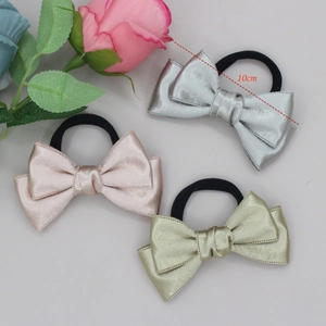 Three shiny satin bow hair ties in silver, pink, and gold, measuring 10cm in width