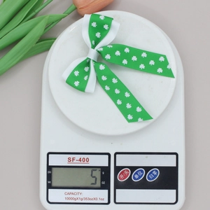 Detail view of St. Patrick's Day shamrock hair clip on a digital scale weighing 5 grams