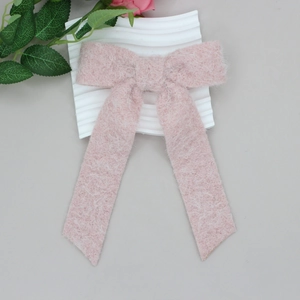Rosa Plüsch-Haarspange mit langer Schleife auf weißem Wellenständer für Mädchen