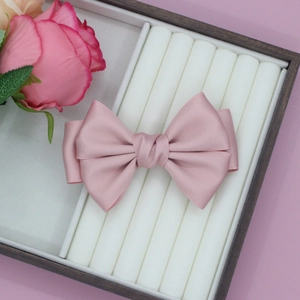 Detailansicht der eleganten rosa Satin-Haarschleife in einer hochwertigen Geschenkbox