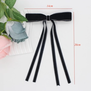 Elegant black velvet bow hair clip with white polka dots measuring 14cm by 20cm