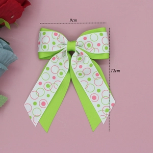 Vue détaillée du nœud en ruban gros-grain à pois vert et blanc de 12x9cm pour fille