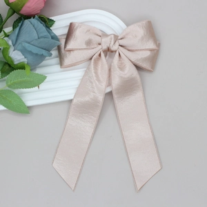 Detailed view of high-quality champagne satin bow hair clip with fine silk texture