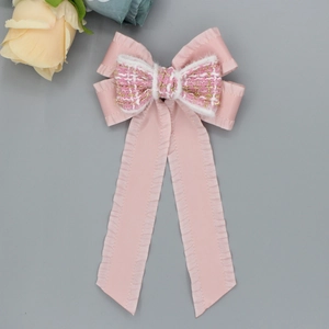 Pink bow hair clip with pleated ribbons and elegant tweed texture for a sweet princess look
