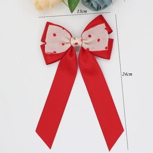 Detail view of large red polka dot bow hair clip measuring thirteen by twenty four centimeters