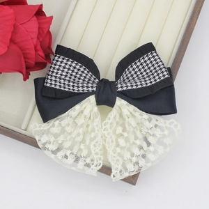 Elegant houndstooth and black satin bow hair clip with lace detail on display box