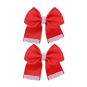 Détail de pinces à cheveux nśuds en ruban rouge avec perles blanches et texture fine