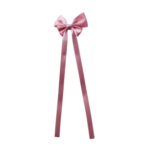 Detail view of pink satin bow hair clip with long ribbons on a plain white background