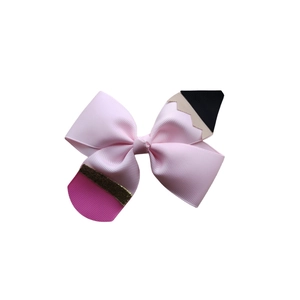 Detailed view of pink ribbon bow hair clip with pencil ends and glitter eraser accents