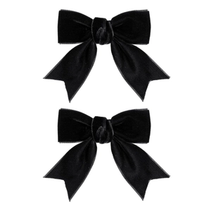 Détail de deux barrettes à nœuds en velours noir style ballerine avec longues queues