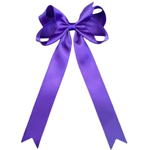 Close-up of deep purple satin bow hairpin with long flowing ribbons and fishtail ends