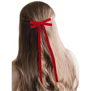 Détail d'un nœud papillon en velours rouge avec de longs rubans pour un style festif