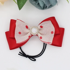 Red polka dot organza bow hair tie for girls featuring a pearl centerpiece and satin layers