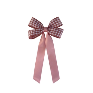Detail of pink houndstooth ribbon hair clip with double-layer bow and long satin streamers
