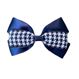 Detail of double-layered bow hair clip with dark blue satin and houndstooth pattern fabric